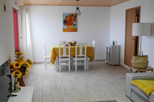 a dining room with a yellow table and chairs at Sunflower Guest House - Pico in São Caetano