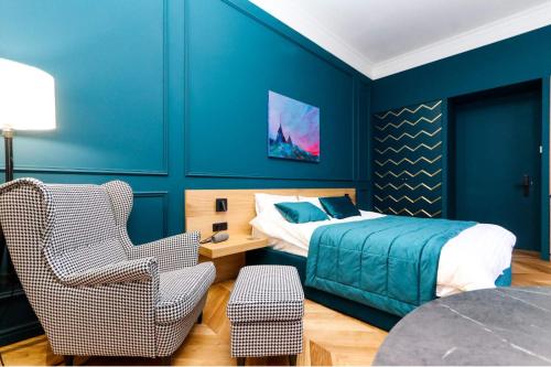 a bedroom with blue walls and a bed and a chair at Once apartments in Ivano-Frankivsʼk