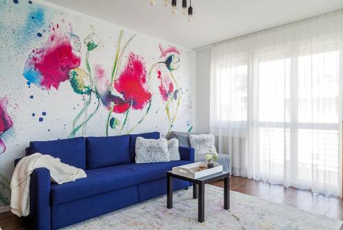 a blue couch in a living room with a painting at Almere with FREE Parking in Budapest