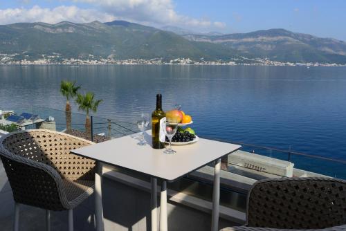 a table with a bottle of wine and fruit on a balcony at Villa Sonja Apartments in Krasici