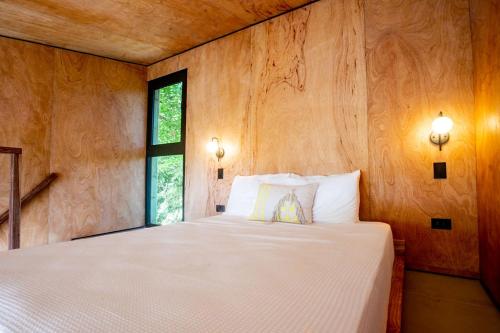 um quarto com uma grande cama branca e uma janela em Tiny Home Samambaia - Sea view and bathtub 