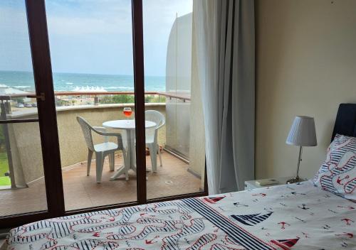 a bedroom with a bed and a view of the ocean at Beach View Apartment in Shkorpilovtsi