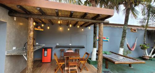 une pergola en bois avec une table et un banc dans l'établissement Hostel Praia Centro Itanhaém, à Itanhaém