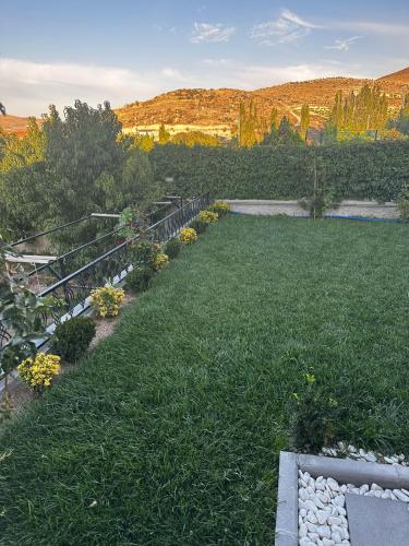 einen Garten mit grünem Gras und Blumen auf einem Hügel in der Unterkunft İç Anadolu 