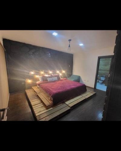 a bedroom with a large bed with lights on it at CUENCA hermosa casa en el campo in Guishil