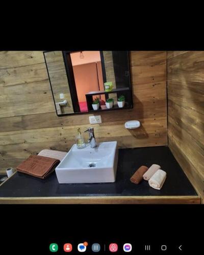 ein Bad mit einem Waschbecken und einem Spiegel in der Unterkunft CUENCA hermosa casa en el campo in Guishil