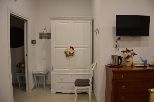 a white cabinet in a room with a television at DIMORA DEL CARMINE in Bari
