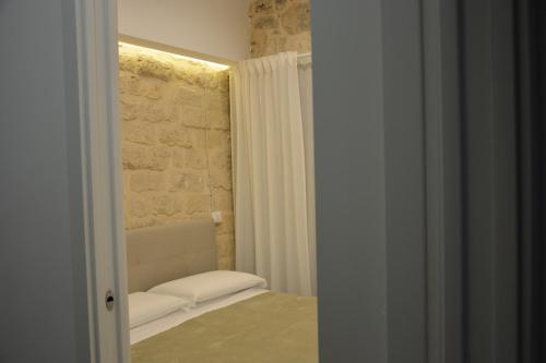 a room with a bed and a stone wall at DIMORA DEL CARMINE in Bari