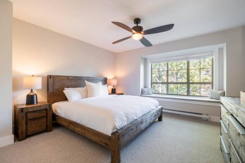 a bedroom with a bed and a ceiling fan at Englewoods Greens by Outpost Whistler in Whistler