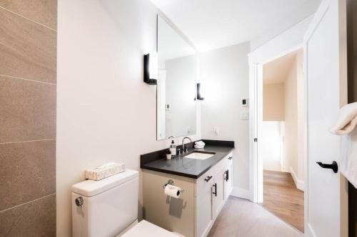 a white bathroom with a sink and a toilet at Englewoods Greens by Outpost Whistler in Whistler