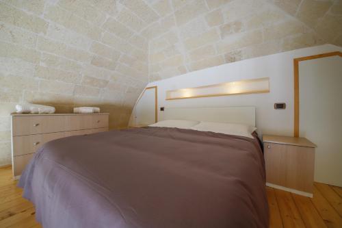 ein Schlafzimmer mit einem großen Bett und einer Steinmauer in der Unterkunft Garibaldi - Affitti Brevi Italia in Gravina in Puglia