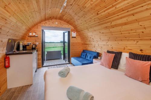 a room with a bed and a kitchen in a cabin at Little Meadow Pods with Hot Tub in York