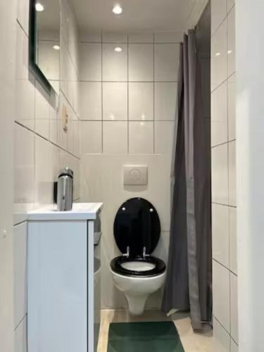La salle de bains est pourvue de toilettes et d'un siège noir. dans l'établissement Flat Chatelain, à Bruxelles