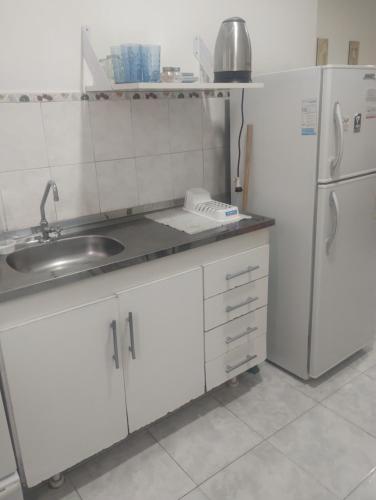 eine Küche mit einer Spüle und einem Kühlschrank in der Unterkunft Apart Belgrano in Corrientes