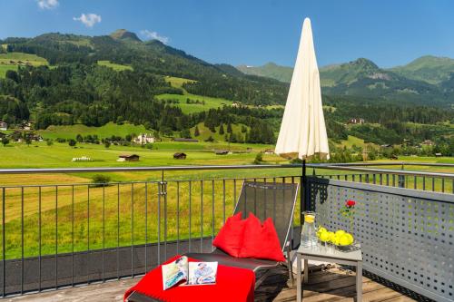 a chair on a balcony with a view of a mountain at Fuchs Apartments - inklusive Eintritt in die Alpentherme Gastein in Bad Hofgastein