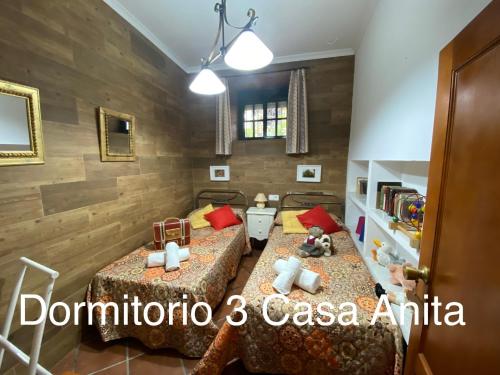 two beds in a room with wooden walls at Casa Rural Paz in Benarrabá