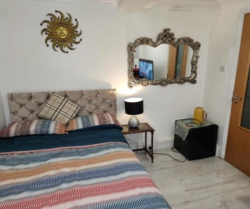 um quarto com uma cama e um espelho na parede em Ensuit Room in Solihull Town Centre em Solihull