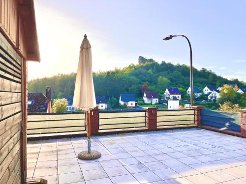 a patio with a white umbrella and a street light at Stilvolles Ferienhaus in Gerolstein in Gerolstein