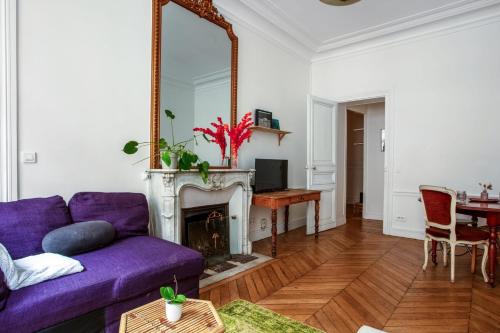 un salon avec un canapé violet et un miroir dans l'établissement Appartement Mercado - Châtelet - Welkeys, à Paris
