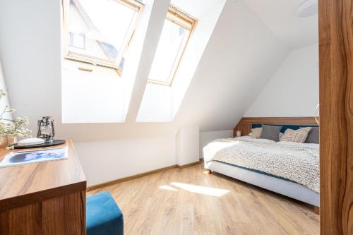 a bedroom with a bed and two windows at Para Apartments - Dwupoziomowe Apartamenty in Biały Dunajec