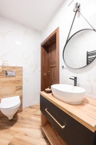 a bathroom with a white sink and a mirror at Para Apartments - Dwupoziomowe Apartamenty in Biały Dunajec