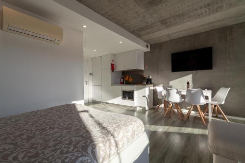 a bedroom with a bed and a table and chairs at Felicidade Aveiro Apartment incl Parking by Home Sweet Home Aveiro in Aveiro