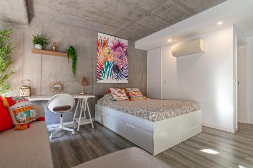 a small bedroom with a bed and a desk at Felicidade Aveiro Apartment incl Parking by Home Sweet Home Aveiro in Aveiro