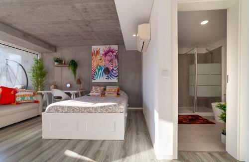 a bedroom with a bed with a painting on the wall at Felicidade Aveiro Apartment incl Parking by Home Sweet Home Aveiro in Aveiro