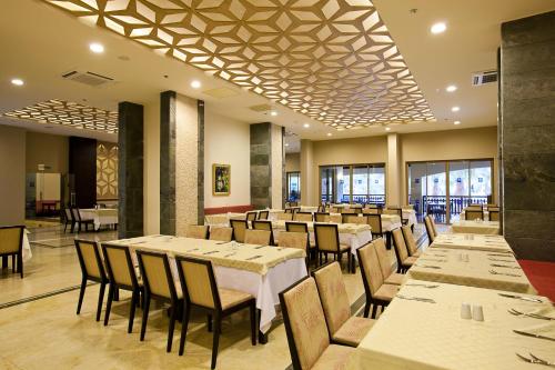 a dining room with white tables and chairs at Club Melas Privé in Side