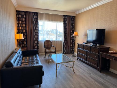 a living room with a couch and a flat screen tv at Garden Suite Hotel and Resort in Los Angeles