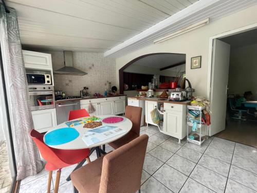 eine Küche mit einem Tisch und Stühlen im Zimmer in der Unterkunft À 15’ de Poe Belle Villa in Bourail