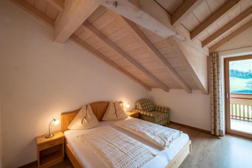 um quarto com uma cama e uma grande janela em Messnerhof, Durnholz em Valdurna