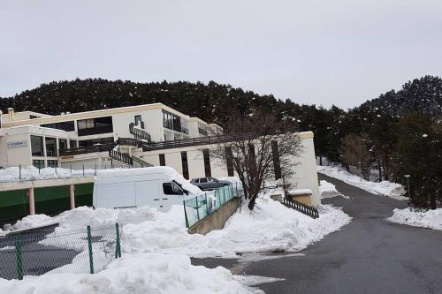 a white van parked in front of a building with snow at résidence les balcons du golf de Font-Romeu in Égat