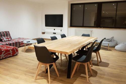 a dining room with a wooden table and chairs at résidence les balcons du golf de Font-Romeu in Égat