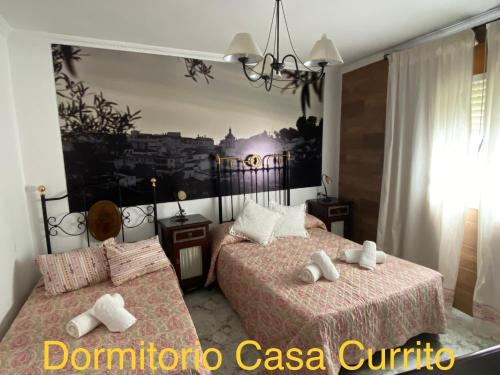 a bedroom with two beds and a picture of a city at Casa Rural Paz in Benarrabá