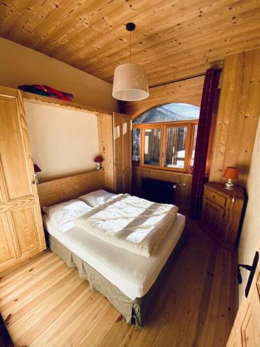 une chambre avec un lit dans une pièce en bois dans l'établissement Appartement cosy avec jardin, à Saint-Jean-dʼAulps