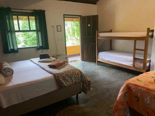 a bedroom with two beds and a bunk bed at Pousada Rancho da Serra PETAR in Iporanga