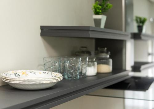 a counter with a bowl and a plate on a shelf at Apto Adilson in Foz do Iguaçu