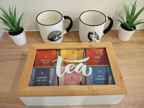 a book shelf with three coffee cups and books at Le Beau Refuge Parisien de Cergy - Parisian modern flat at Cergy in Cergy