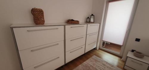 a white dresser in a room with a window at Magda Apartment in Sibiu