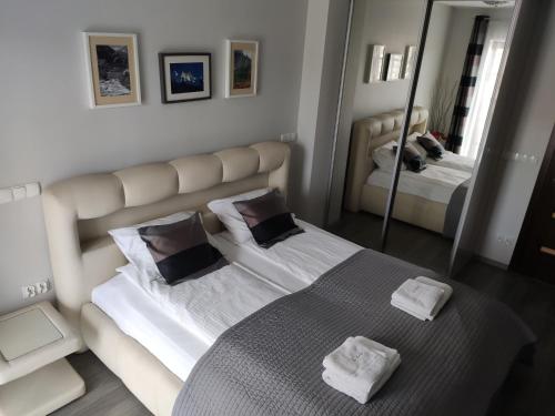 een slaapkamer met een groot bed en 2 handdoeken bij San Marino in Zakopane
