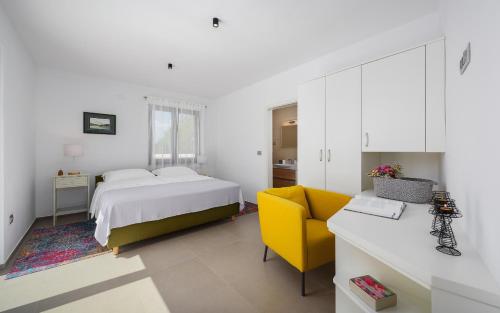 um quarto com uma cama e uma cadeira amarela em Villa Cangarela 115 em Visnjan