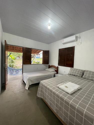 1 dormitorio con 2 camas y ventana en Sítio Paraíso do Caju, en Barreirinhas