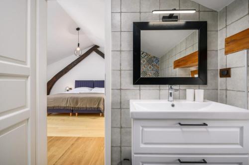 een badkamer met een wastafel en een spiegel en een slaapkamer bij Villa Cangarela 117 in Višnjan