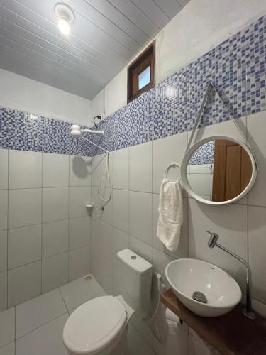 een badkamer met een toilet, een wastafel en een spiegel bij Sítio Paraíso do Caju in Barreirinhas