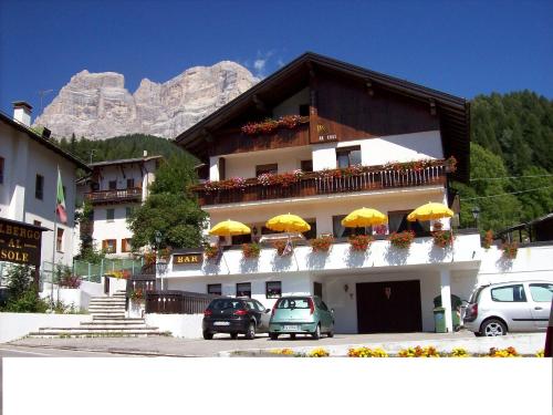 a building with yellow umbrellas in front of it at Albergo al Sole in Val di Zoldo