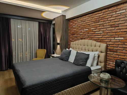 a bedroom with a bed and a brick wall at Nomad Hub Istanbul Residence in Istanbul