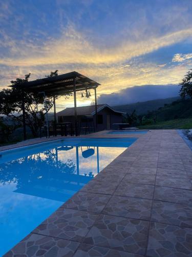 a swimming pool with a gazebo next to a house at La Flor de Loto in Cartago