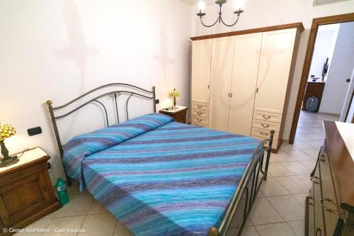 a bedroom with a bed with a blue striped blanket at Vento Mare Palau in Palau