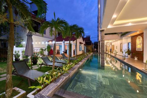 una piscina en una villa por la noche en Legend Ancient Town Hoi An Hotel, en Hoi An